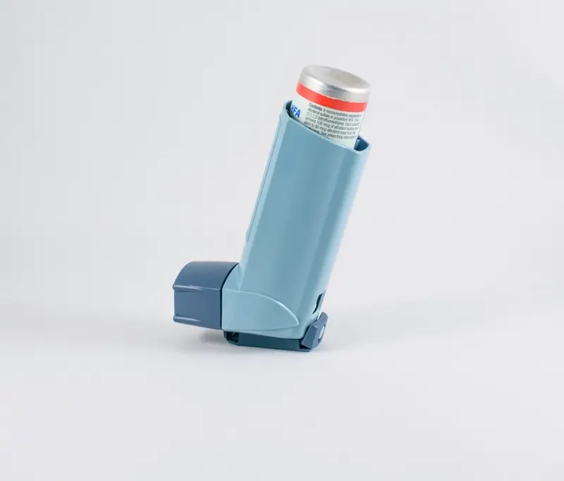 Person holding an asthma inhaler